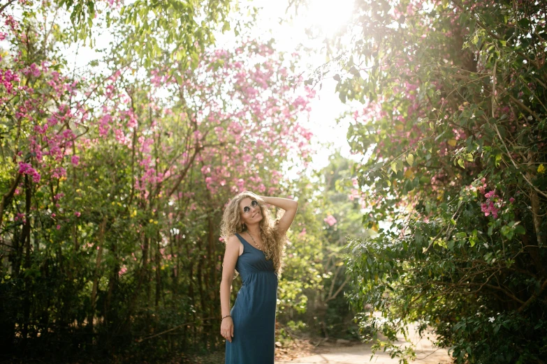 a beautiful woman posing for the camera wearing a dress and hat