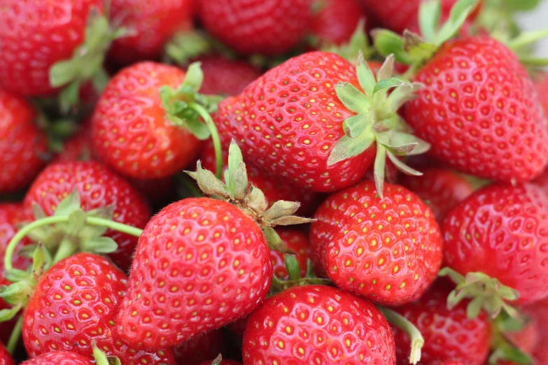 red strawberries are stacked on top of each other