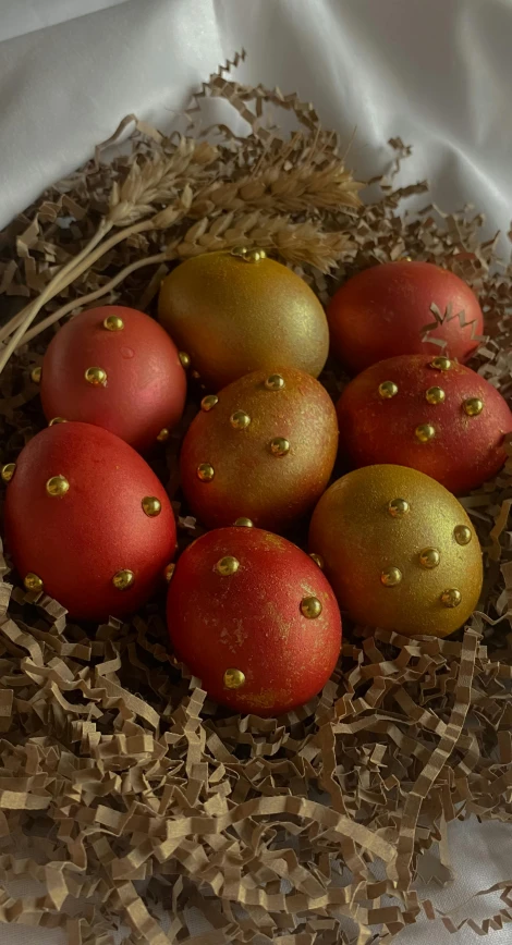 some red eggs in a basket of hay