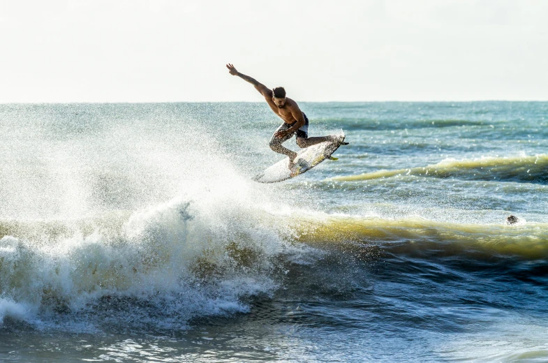 a man flying through the air on top of a wave