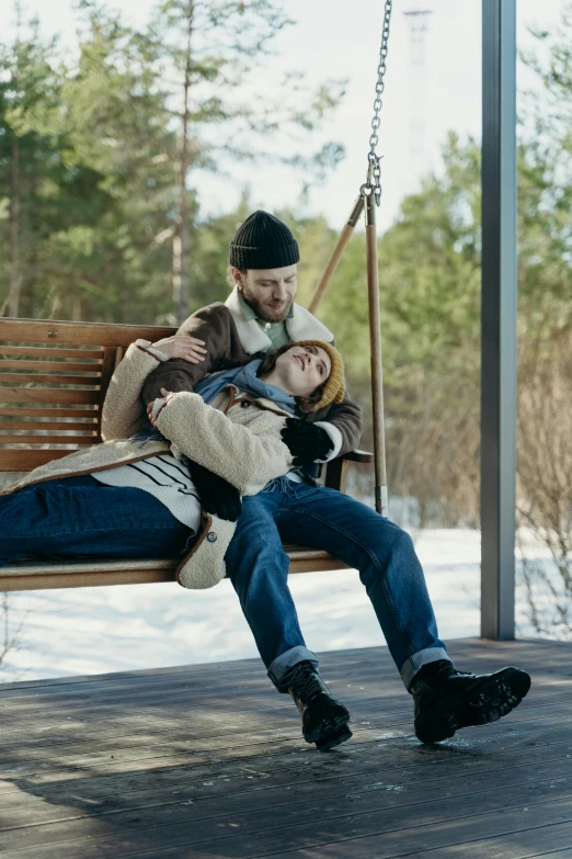 a man and a woman sleeping on a swing