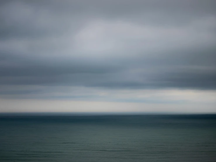 a lone boat on the ocean under some stormy skies