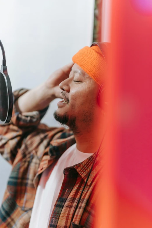 a man with an orange head band and a blue hat singing