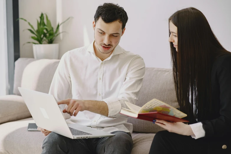 man and woman sitting on a couch using laptop computers