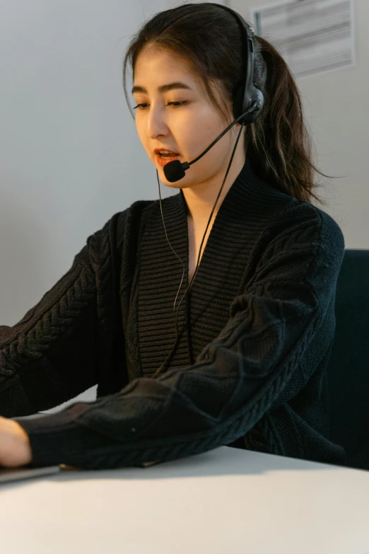 a person with a headphone on sitting at a desk