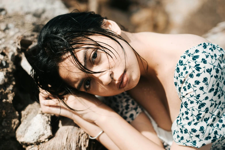 a woman is posing in an off white floral top