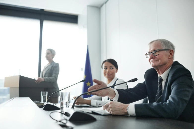 three people at a table smiling while the man is speaking