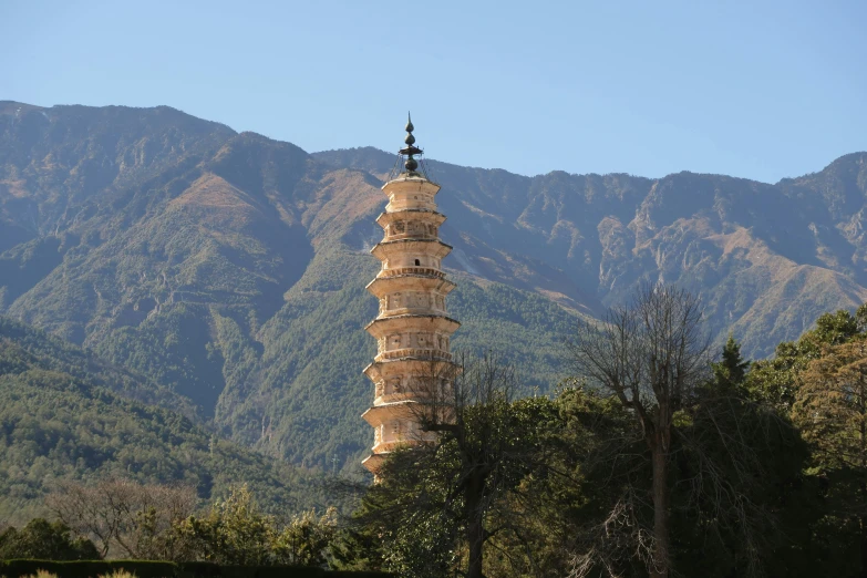 a tall tower near mountains with a sky background