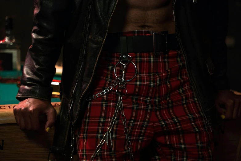 a shirtless man is wearing a red plaid belt