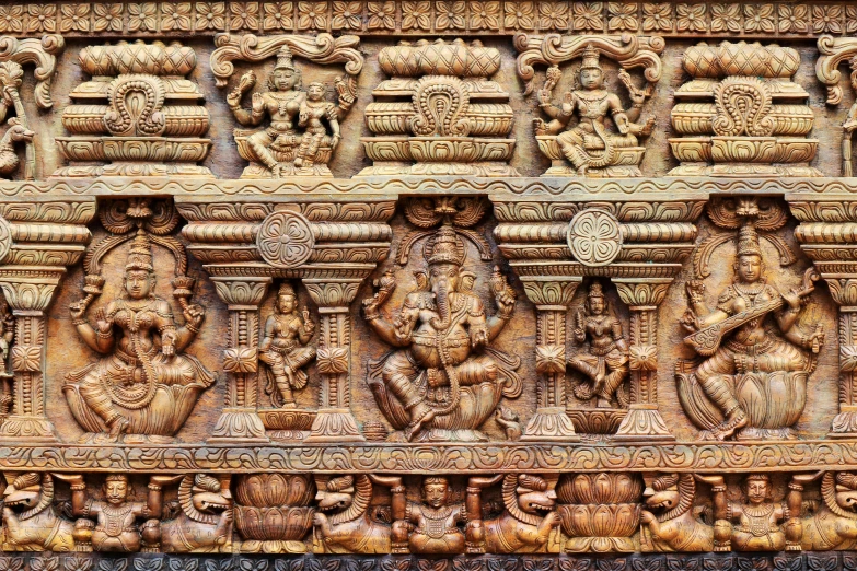 carved wood panel depicting ganesh and the goddesses