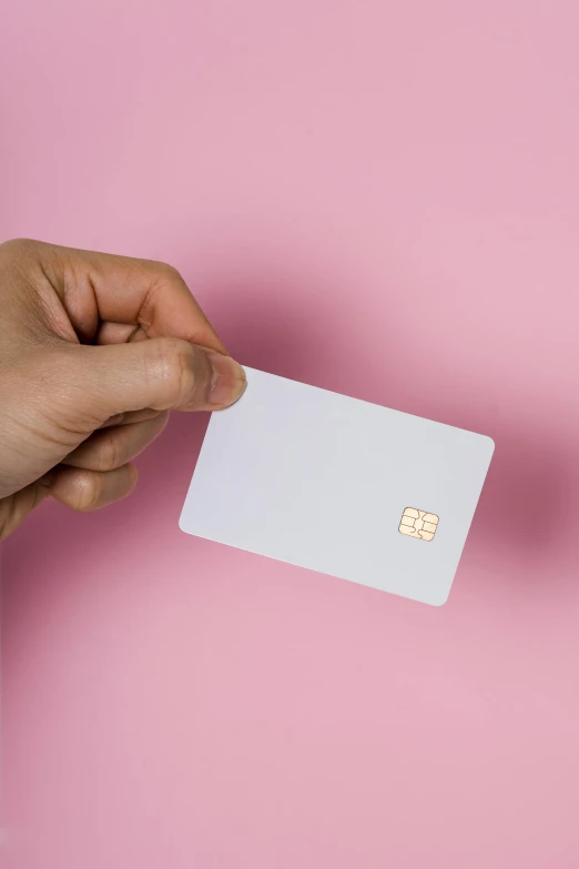 a hand holds an empty business card with a small square on