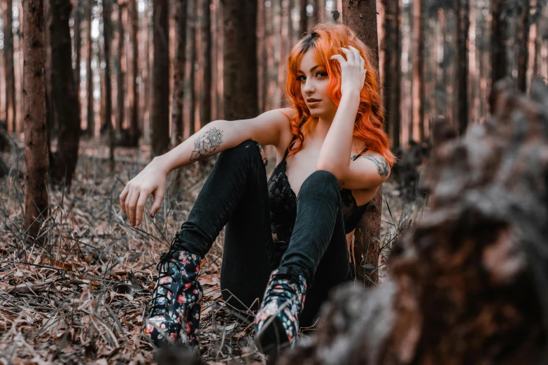 a beautiful redhead girl sitting in the woods