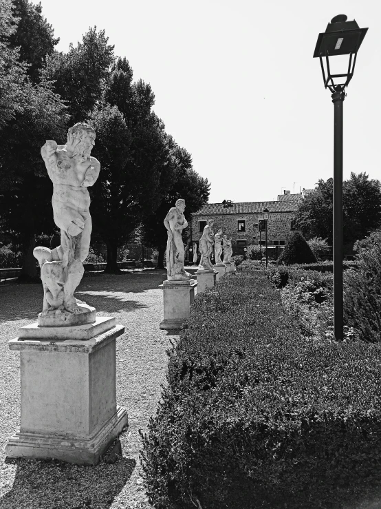 there are statues sitting in a field near a street light