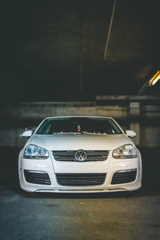 the front of a white car in a parking garage