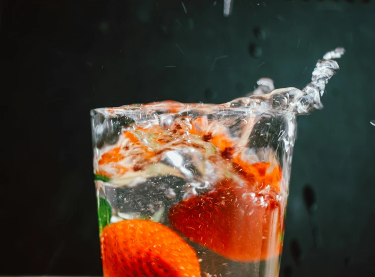 a orange slice is on the edge of a glass filled with water