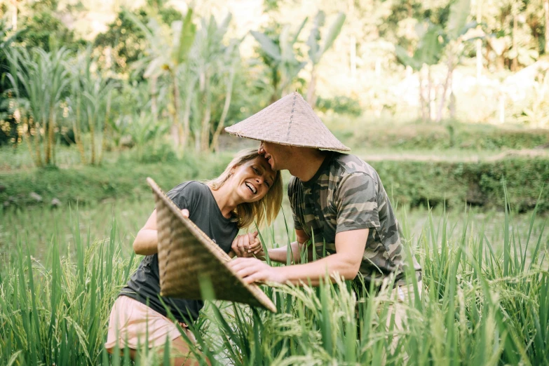 two people sitting on the ground in the grass
