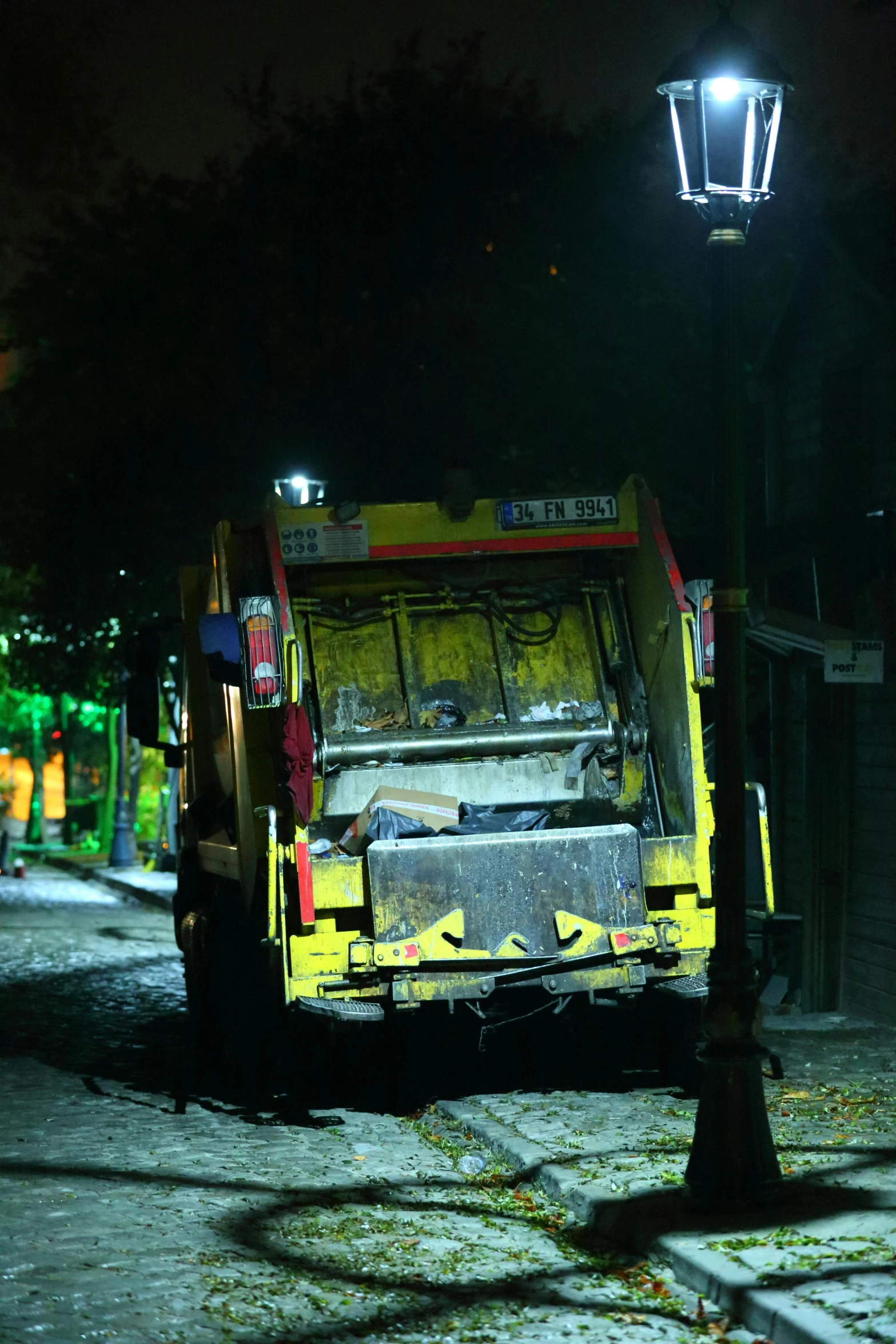 a garbage truck at night on a street