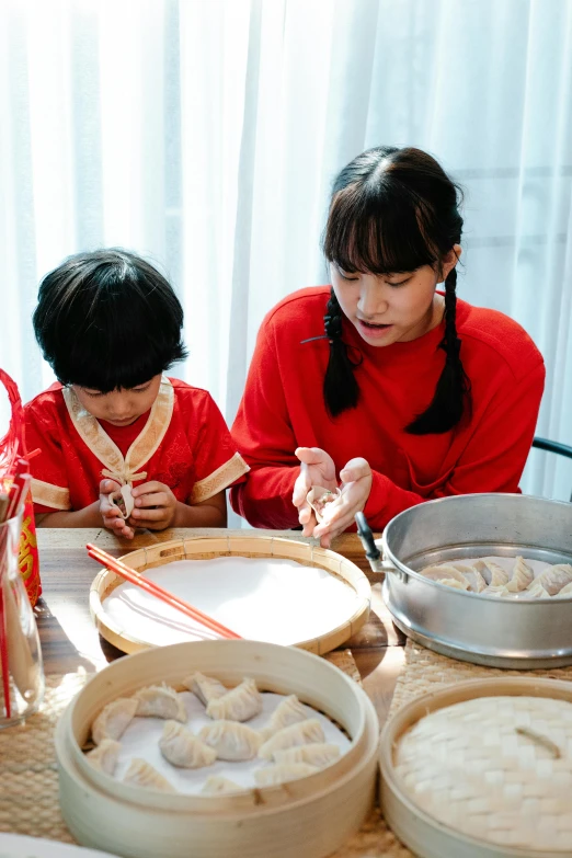 mother and child making dumplings in a japanese cuisine