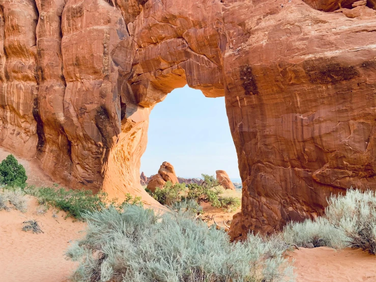 the rock wall next to the cave has an opening