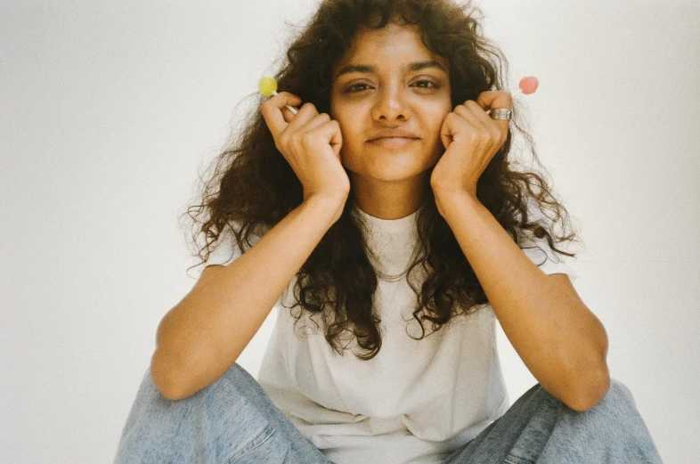 a woman with curly hair sits on the ground