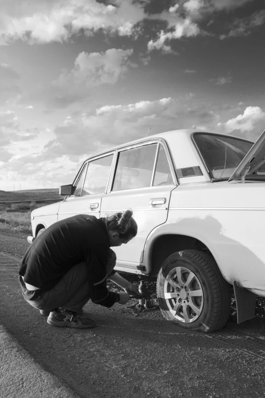 a black and white po of a man working on a car