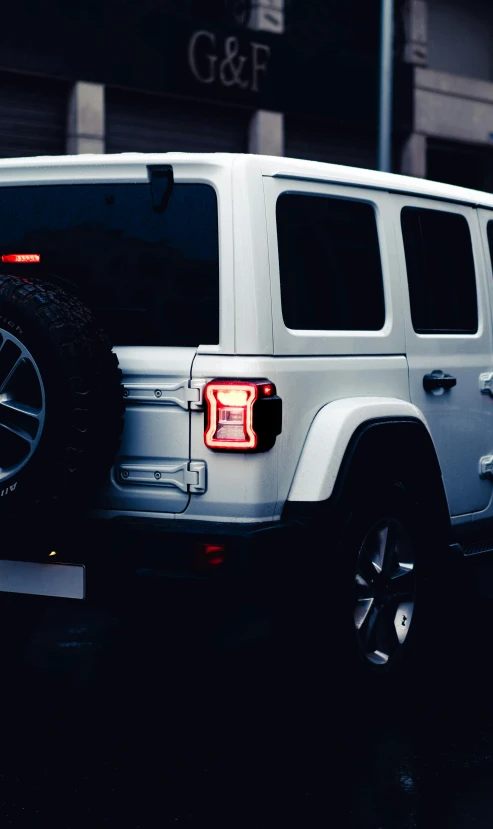 a white jeep parked on the side of a road