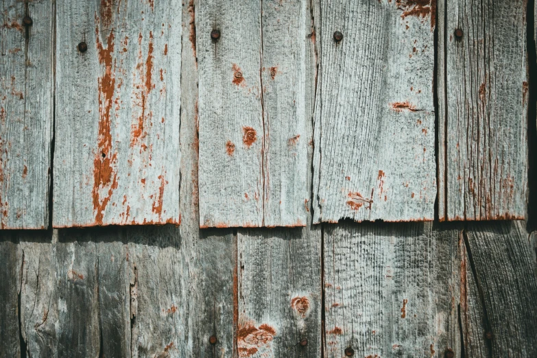 the wooden wall with chipped paint has peeling paint