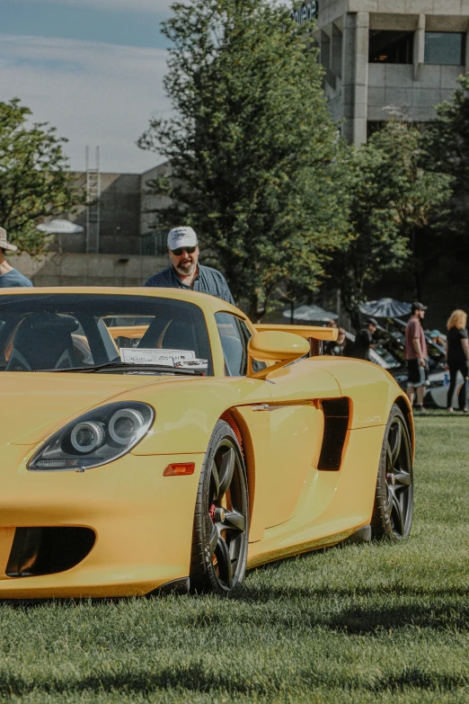 an orange sports car parked in the grass