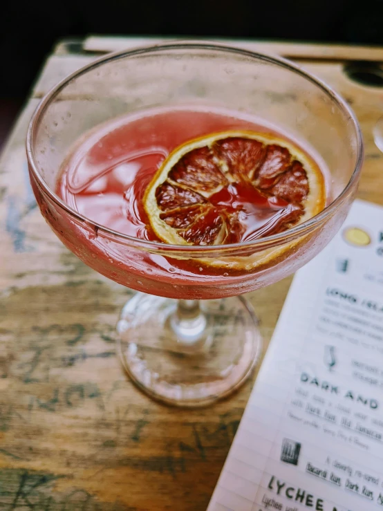 a red drink in a glass on top of a table