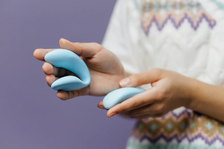 a hand holding a blue object in their palm