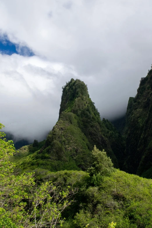 a lush green hillside sits beneath a cloudy sky