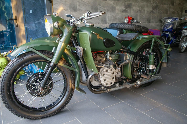 old style motorcycle sitting in front of a building