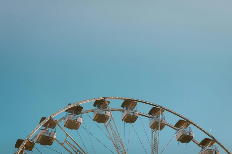 a ferris wheel sits against a bright blue sky