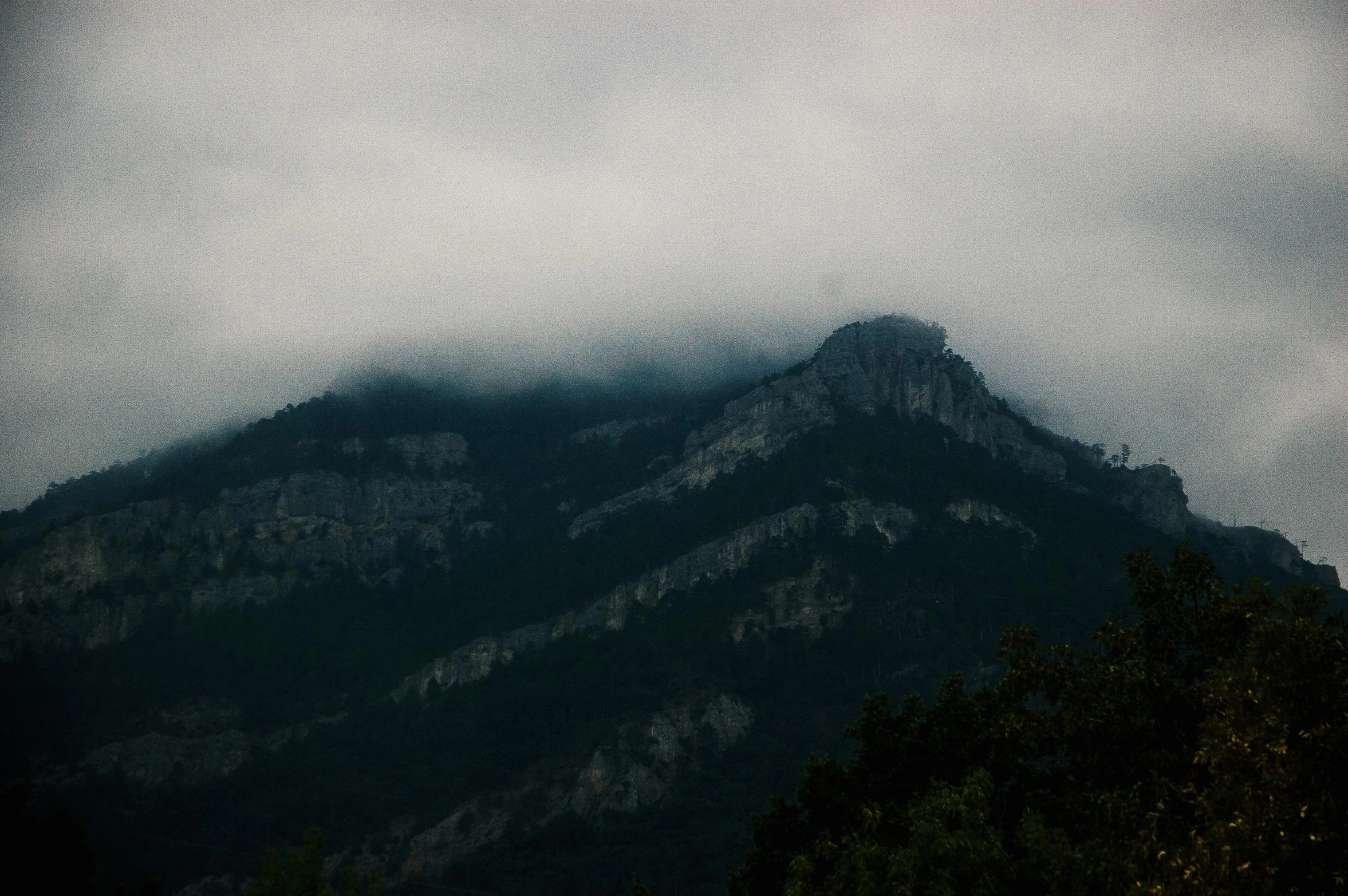 a large mountain is shown covered by clouds