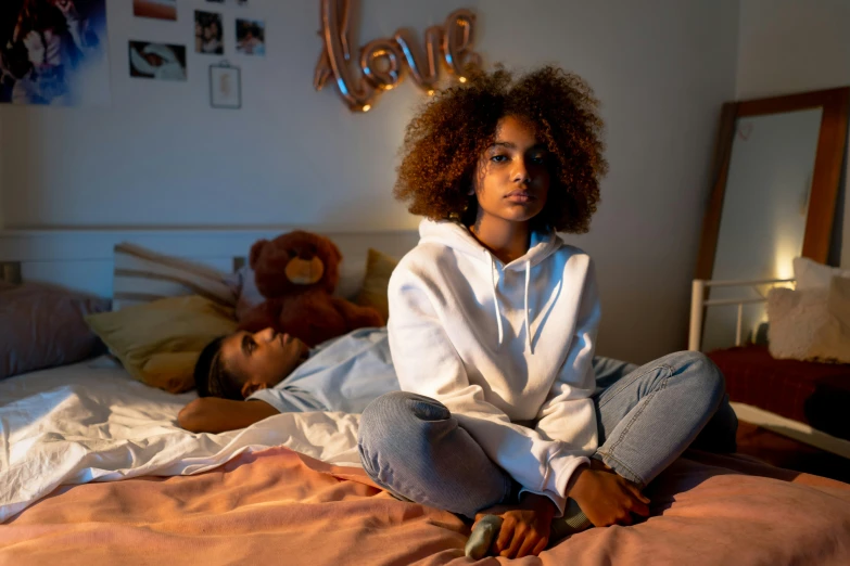 a girl is sitting on a bed in a room