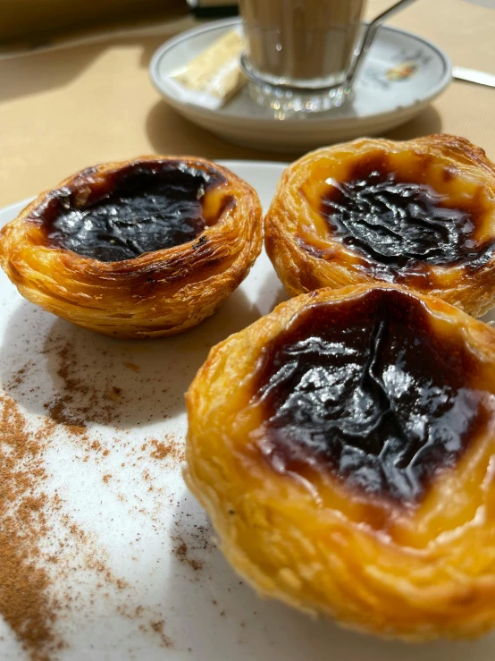 desserts sit on a plate beside an espresso