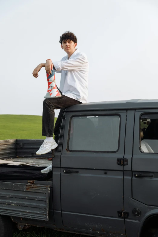 a young man sitting on the back of a truck