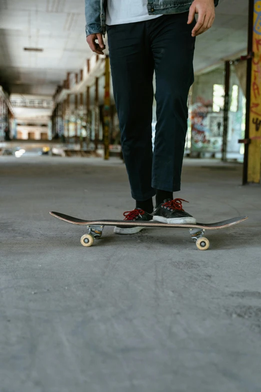 a man standing with his skateboard in a hallway