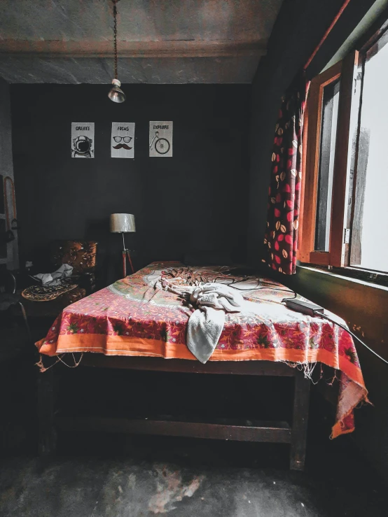 a bed in a room with red curtains and some windows