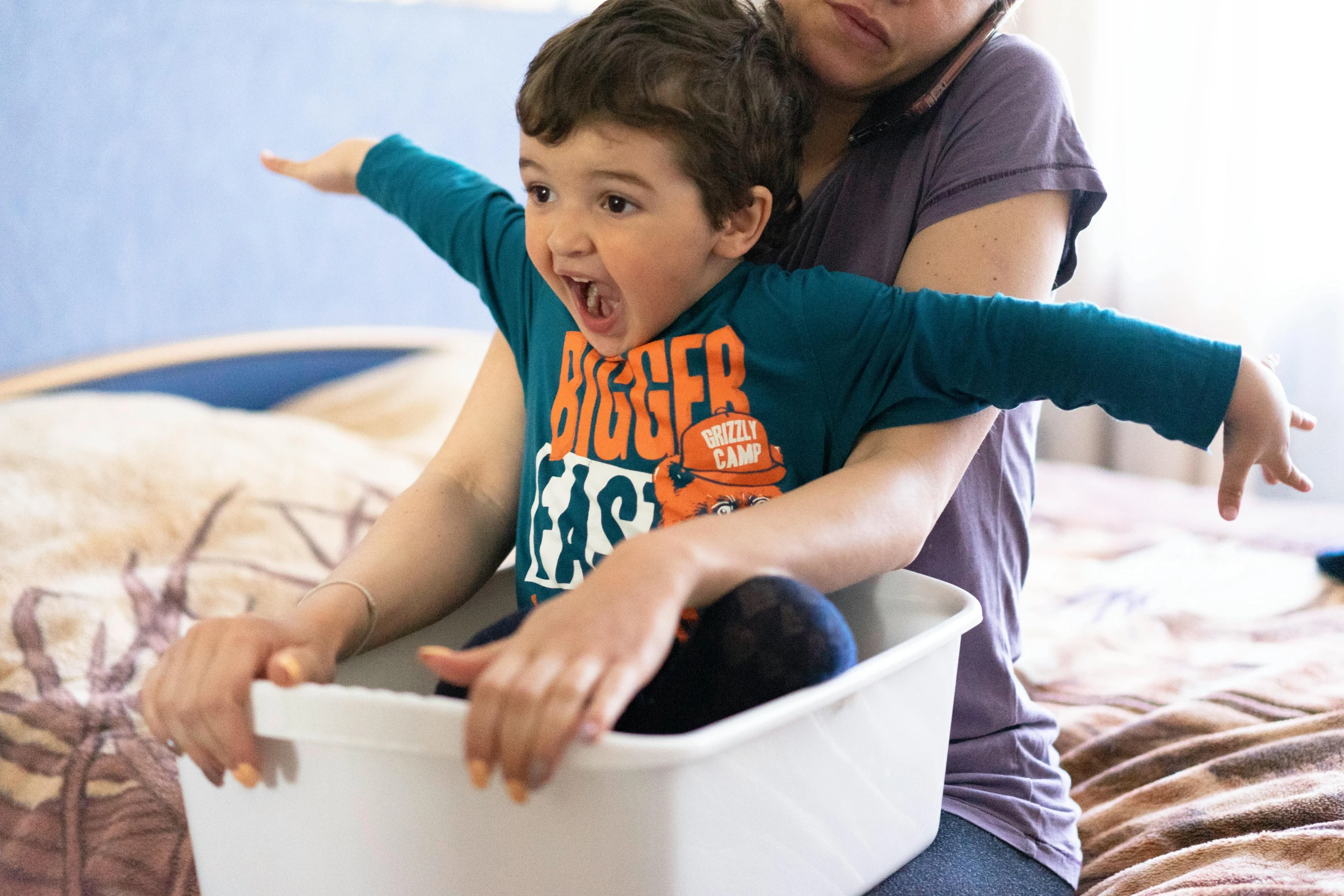 an adult is hugging a child in a white container