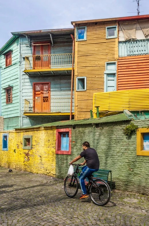 man on bicycle in front of wooden house