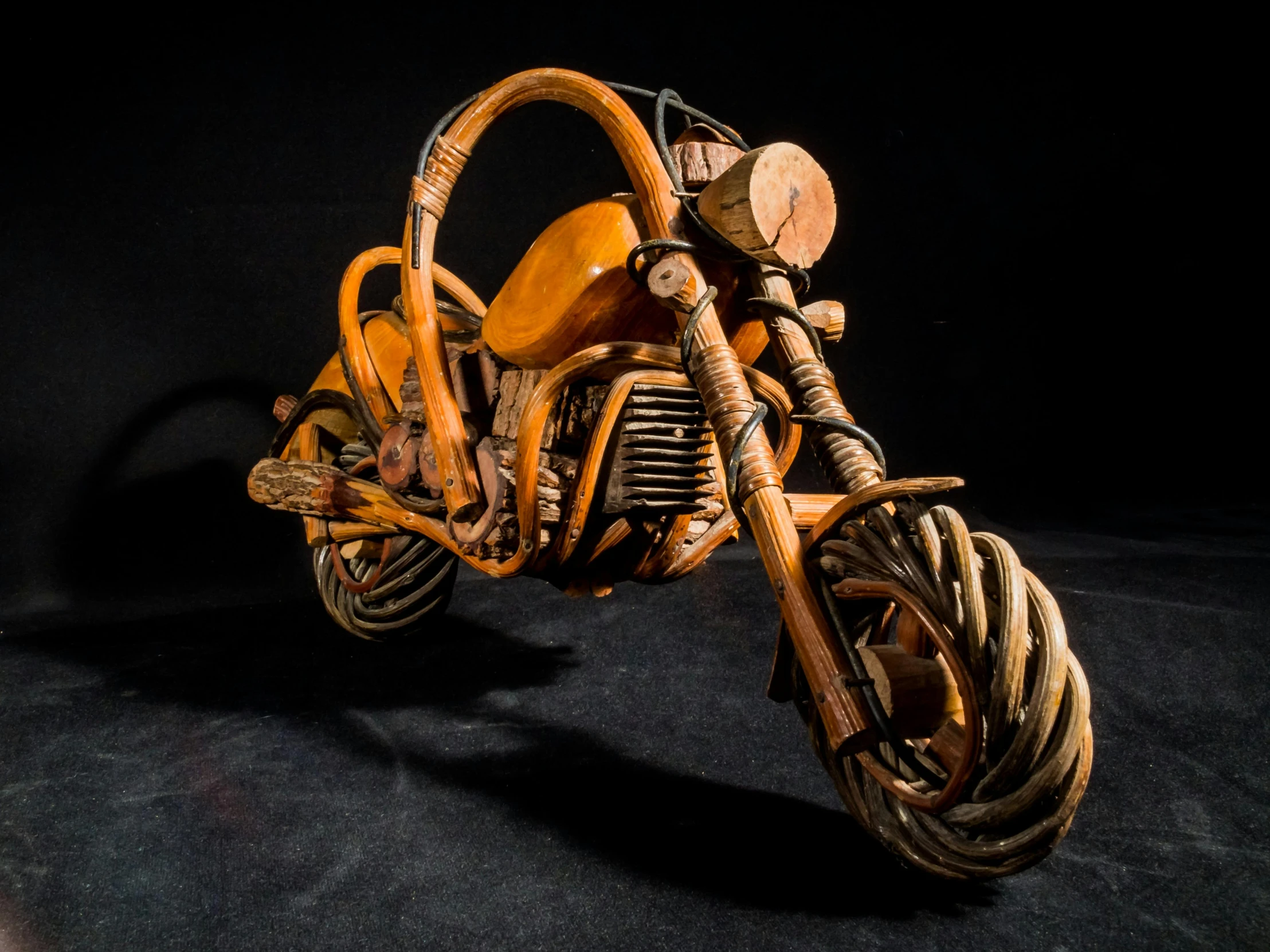 a small wooden motorcycle with a basket strapped around the back tire
