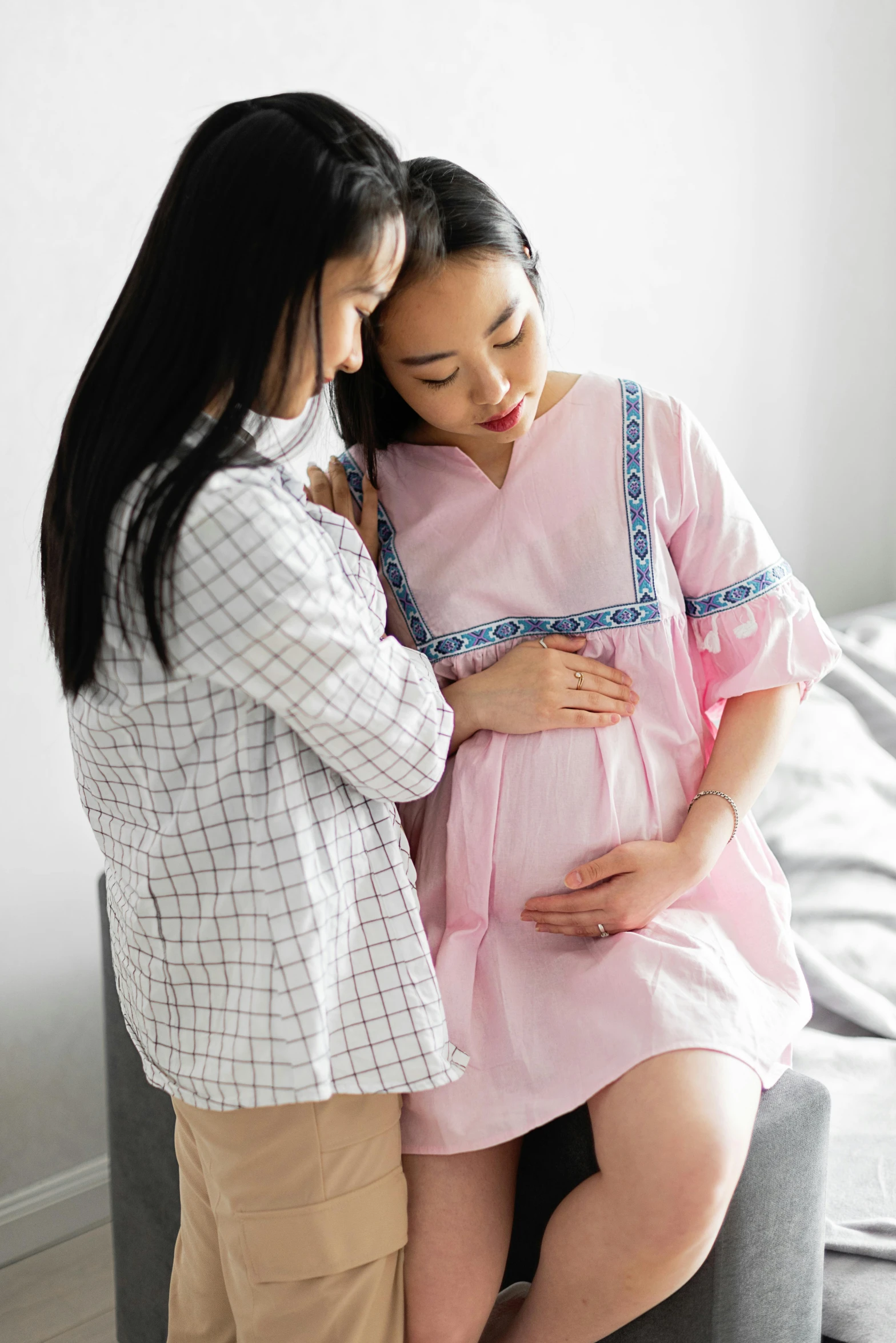 a pregnant couple emce as they pose for the camera