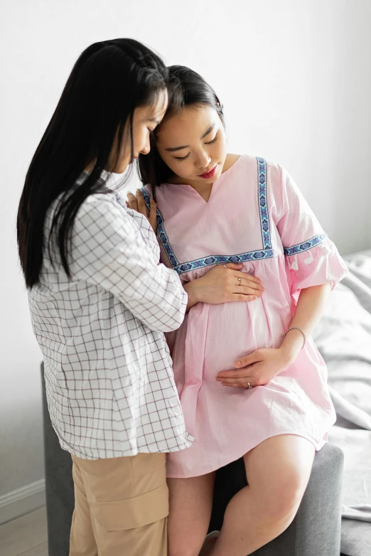 a pregnant couple emce as they pose for the camera