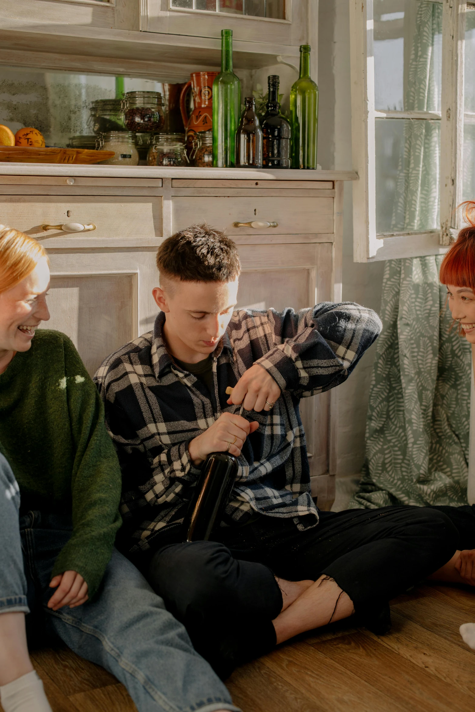 a group of people sit on the floor near a counter