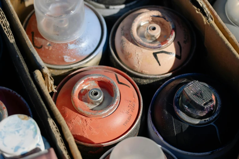 several rusted fire cans in an open cardboard box