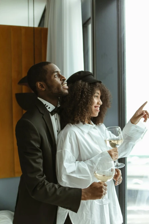 a young couple wearing elegant attire and drinking wine