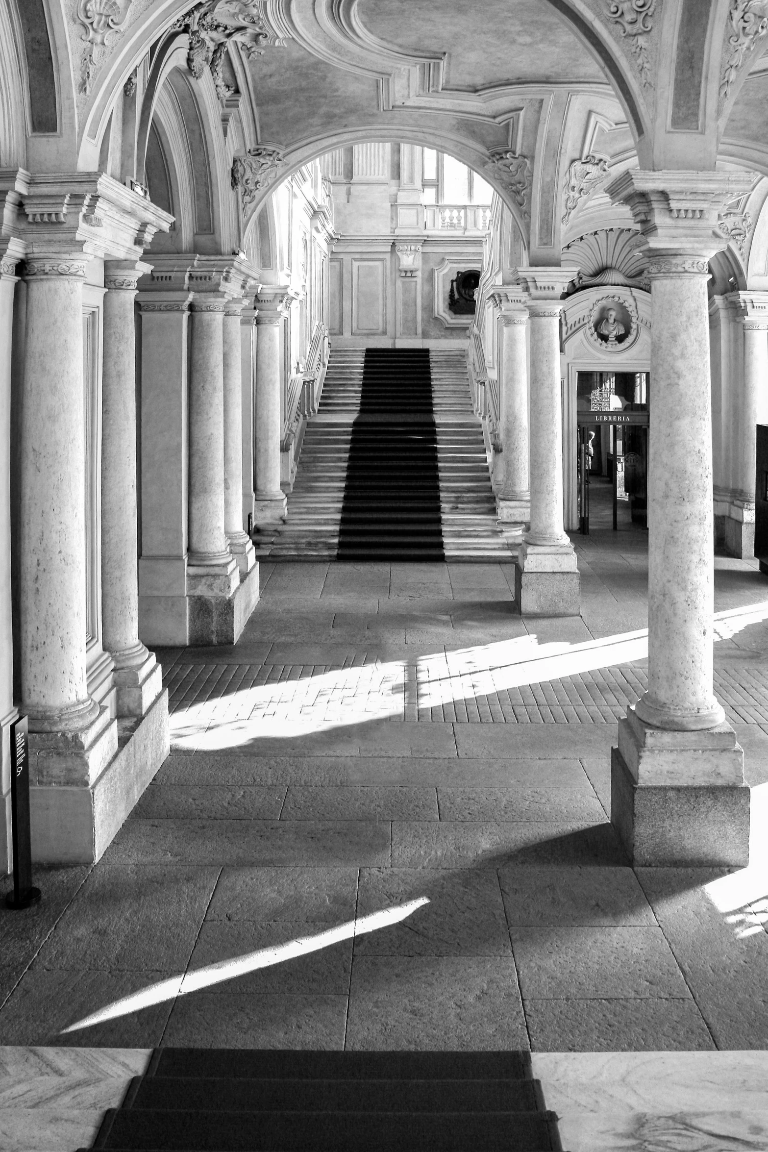 the shadow of a person standing underneath some arches