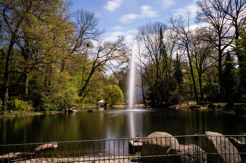 there is a large fountain surrounded by rocks and trees