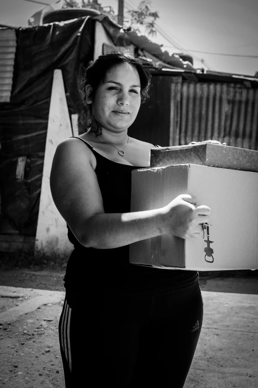 a woman that is standing with a box